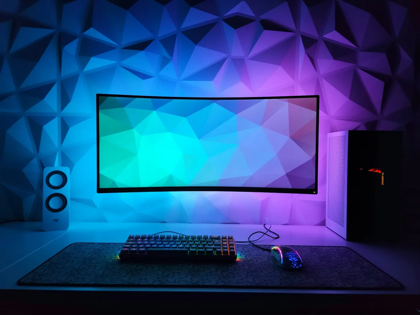 Gaming desk setup with a curved monitor, mechanical keyboard and RGB lighting